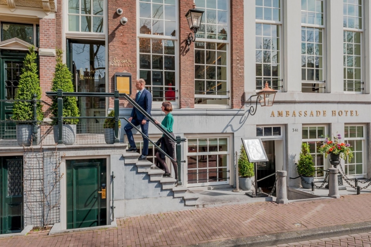 Ambassade Hotel - a man and woman walking up stairs outside a building