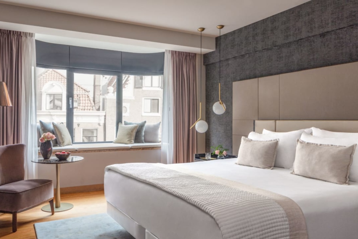 Anantara Grand Hotel Krasnapolsky Amsterdam - a bedroom with a bed and a table
