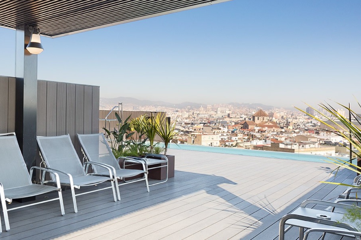 Andante Hotel - a deck with chairs and a view of a city