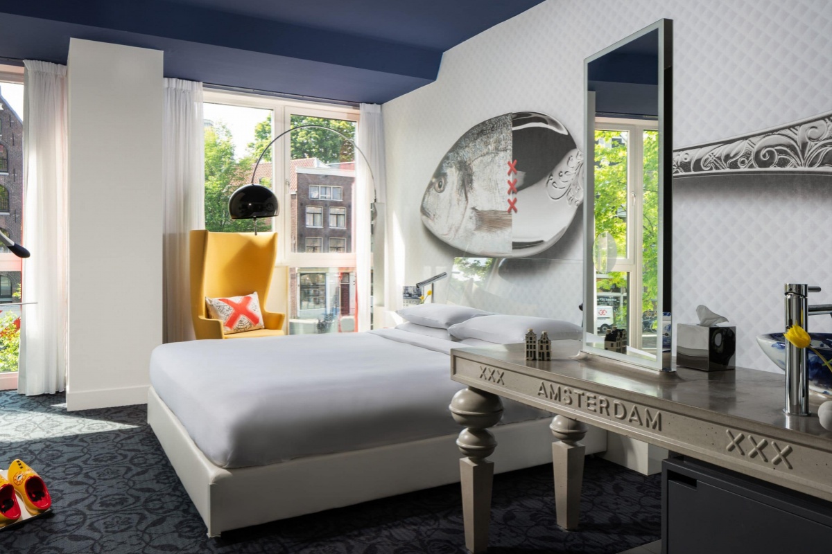 Andaz Amsterdam Prinsengracht - a room with a bed and a mirror