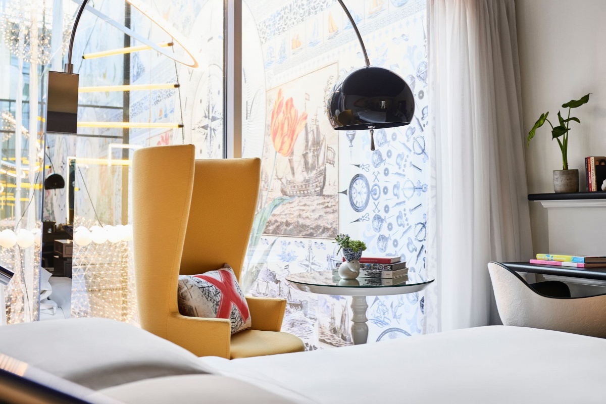 Andaz Amsterdam Prinsengracht - a room with a yellow chair and a lamp