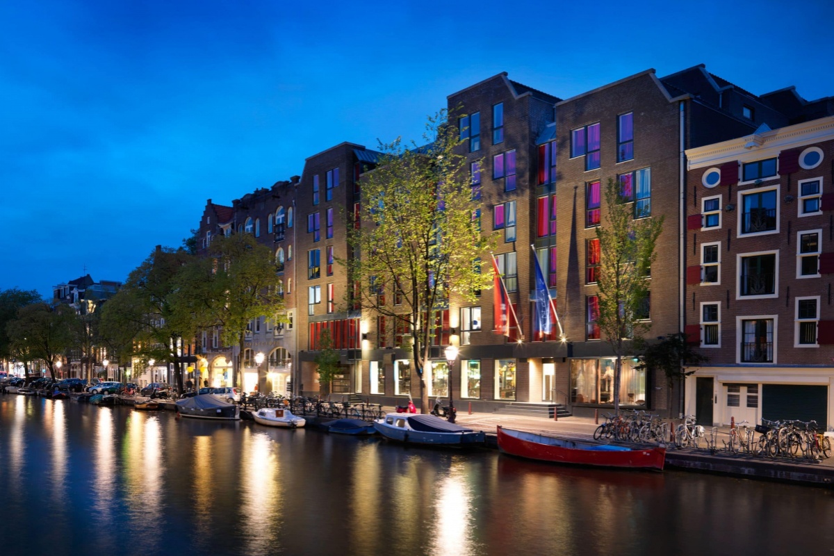 Andaz Amsterdam Prinsengracht - a row of buildings next to a river
