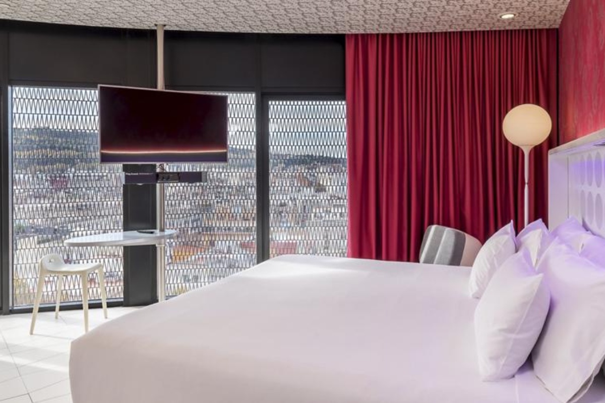 Barcelo Raval - a bed with a television and a window