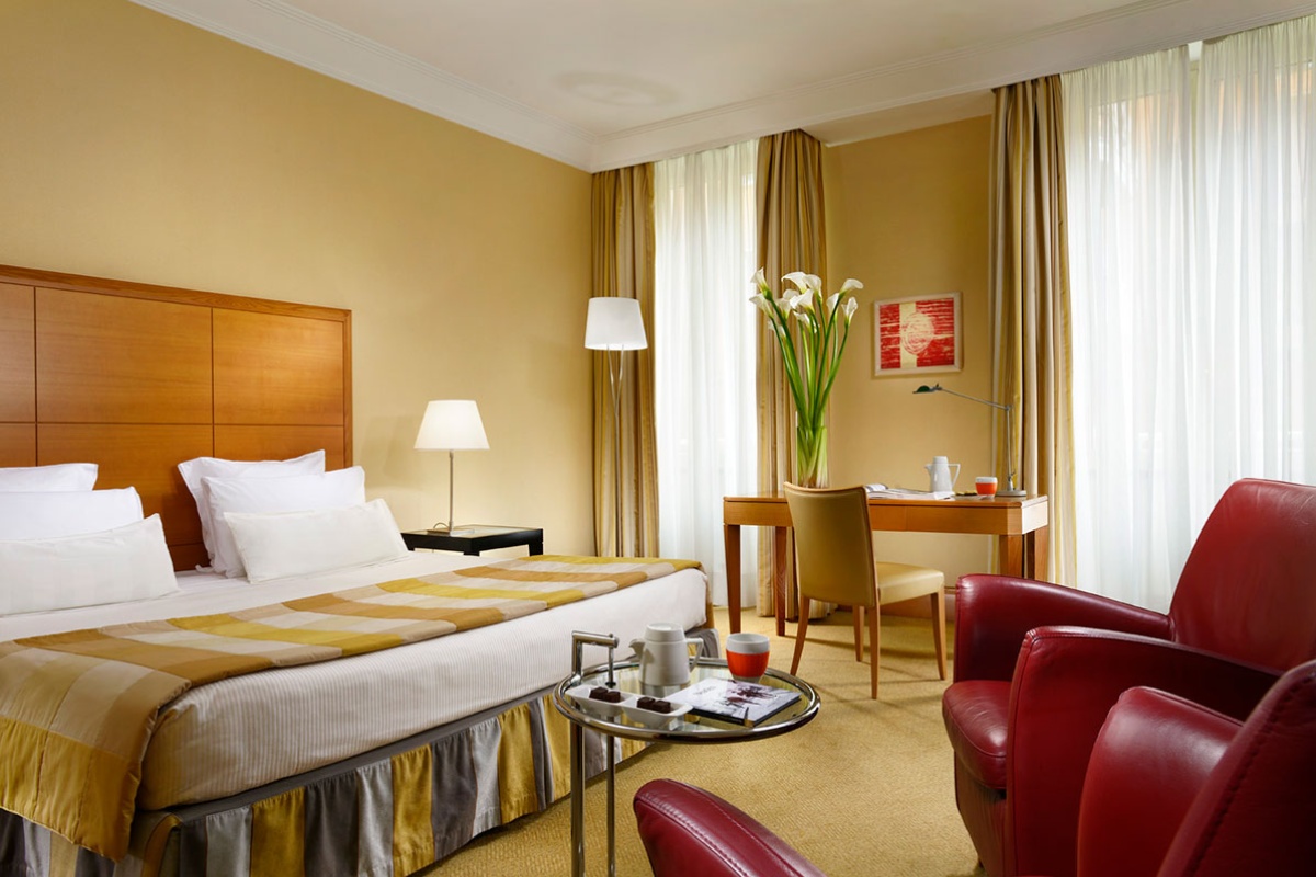 Capo D'Africa Hotel  Colosseo - Double hotel bedroom with plush bedding, soft lighting and elegant decor.