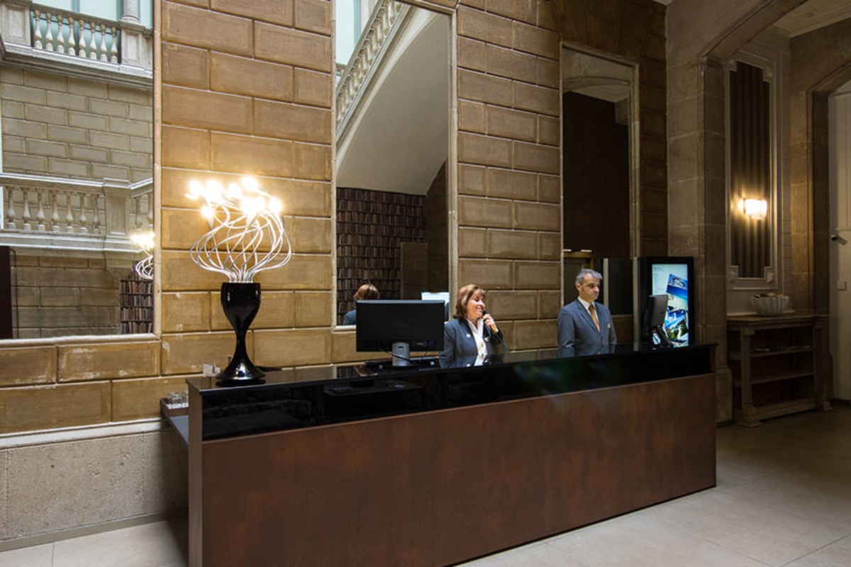 Catalonia Portal de l'Angel - a man and woman standing at a reception desk