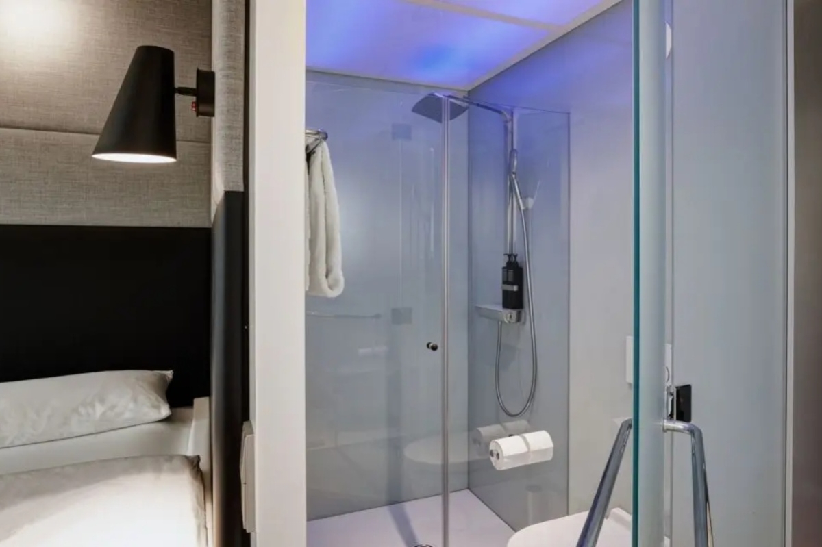 citizenM Amstel Amsterdam - a bathroom with glass shower and a toilet