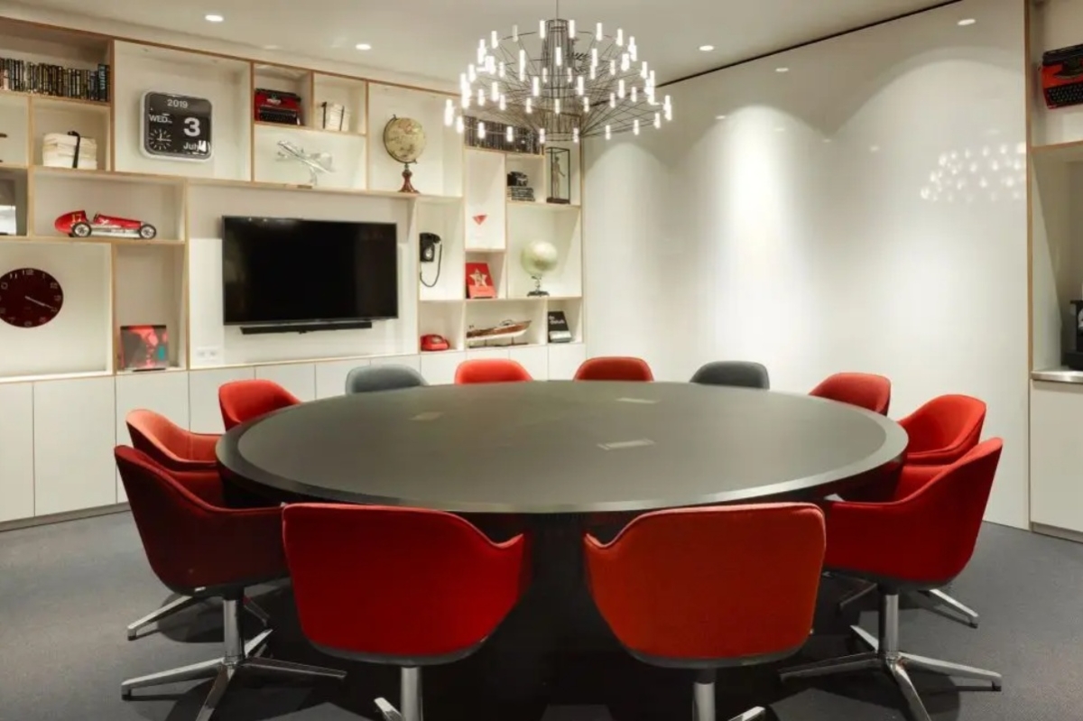 citizenM Amstel Amsterdam - a room with a round table and red chairs