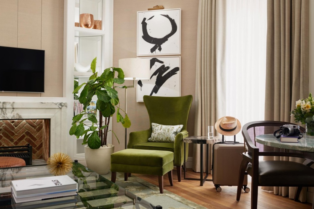 Corinthia Hotel - a living room with a green chair and a green plant