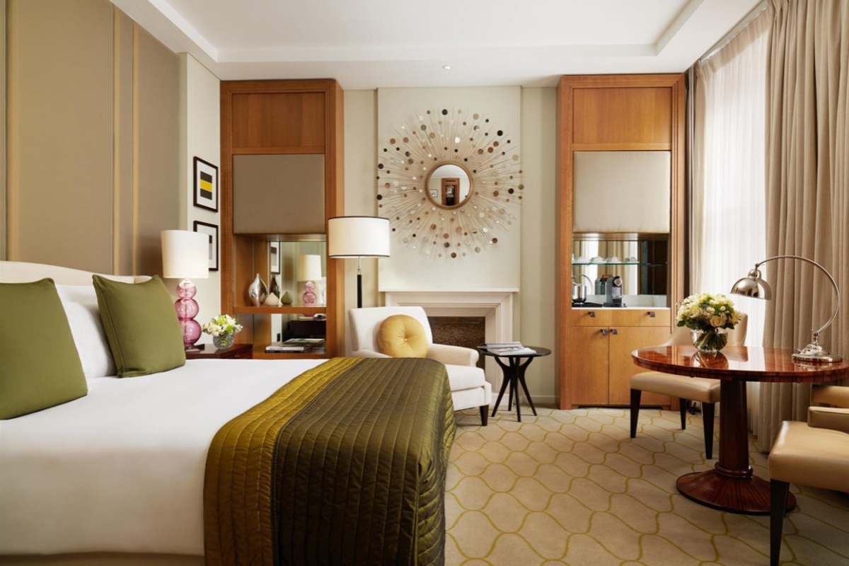 Corinthia Hotel - a room with a bed and a mirror