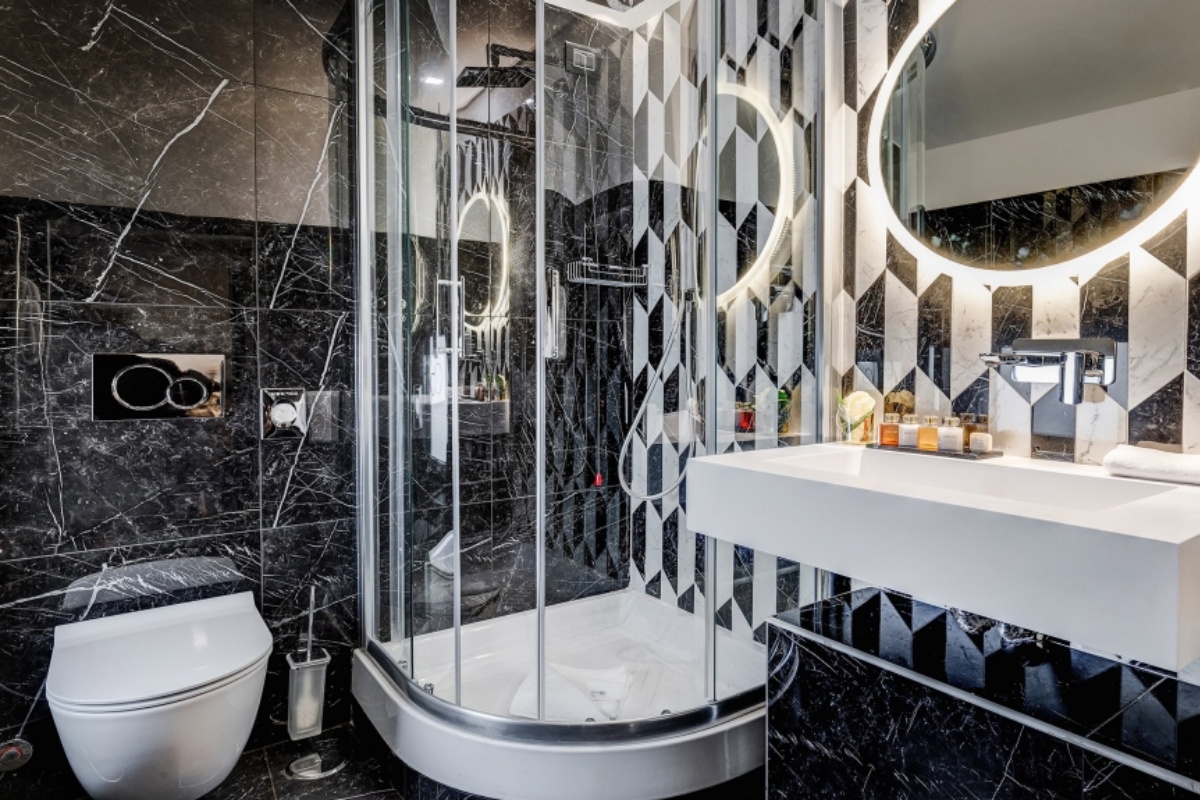 Dharma Boutique Hotel & Spa - Bathroom with black and white marble tiles and corner rainfall shower.