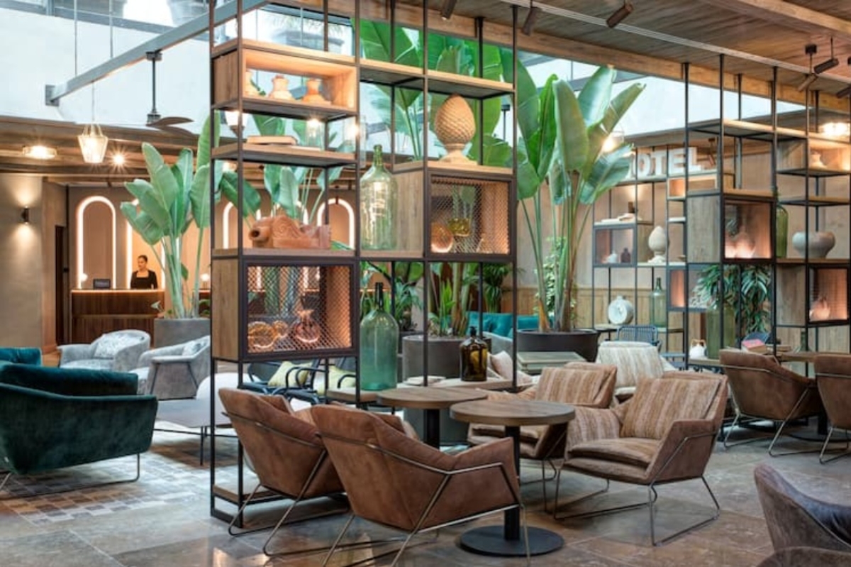 Doubletree by Hilton Rome Monti - Reception area with large green plants and glass atrium roof.