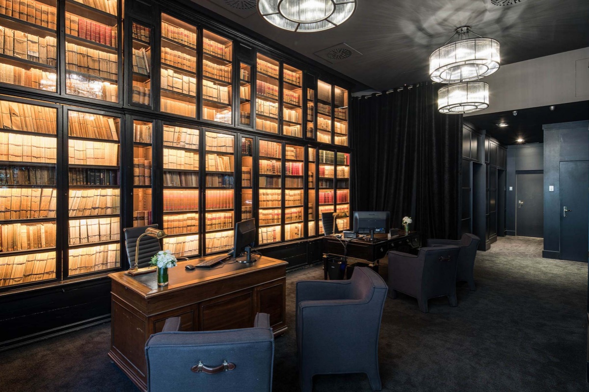 Grand Hotel Central - a room with a desk and a bookcase with books on it