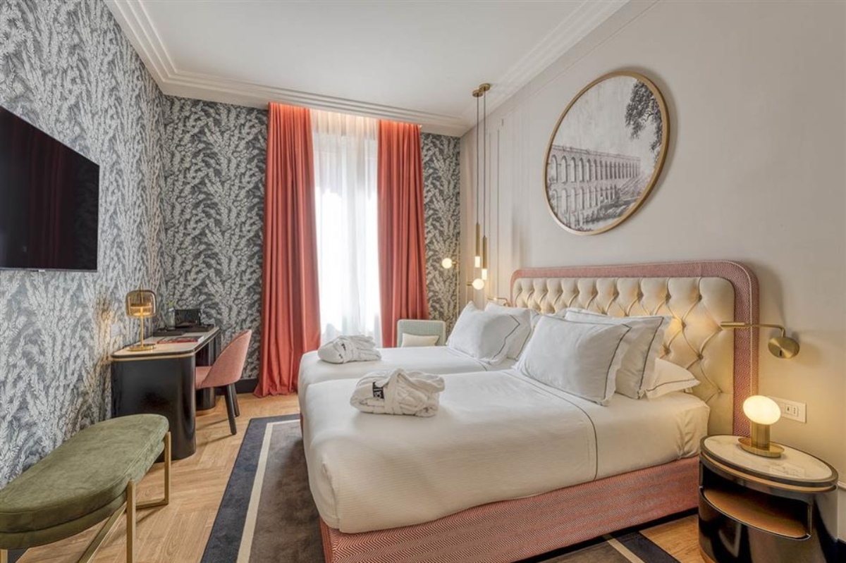 H10 Palazzo Galla - A double bedroom with soft lighting and plush bedding.