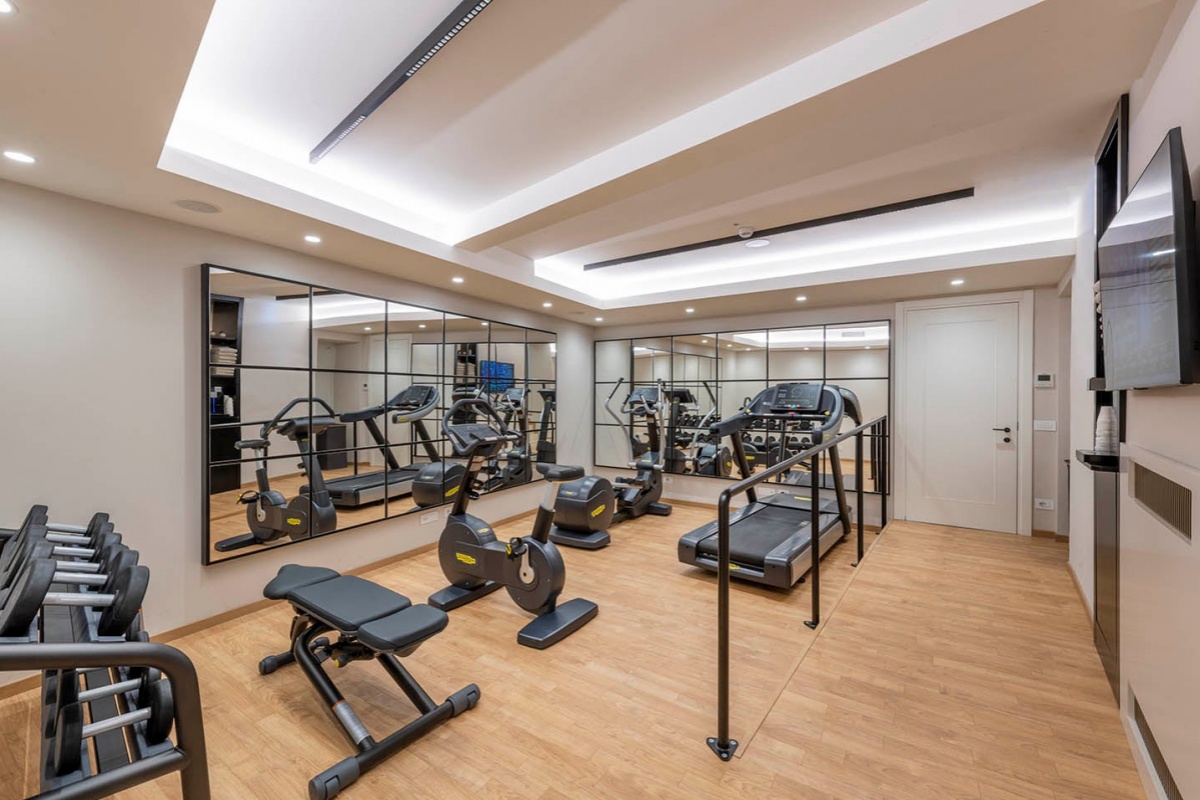H10 Palazzo Galla - Gym with mirrored walls and wooden floor.
