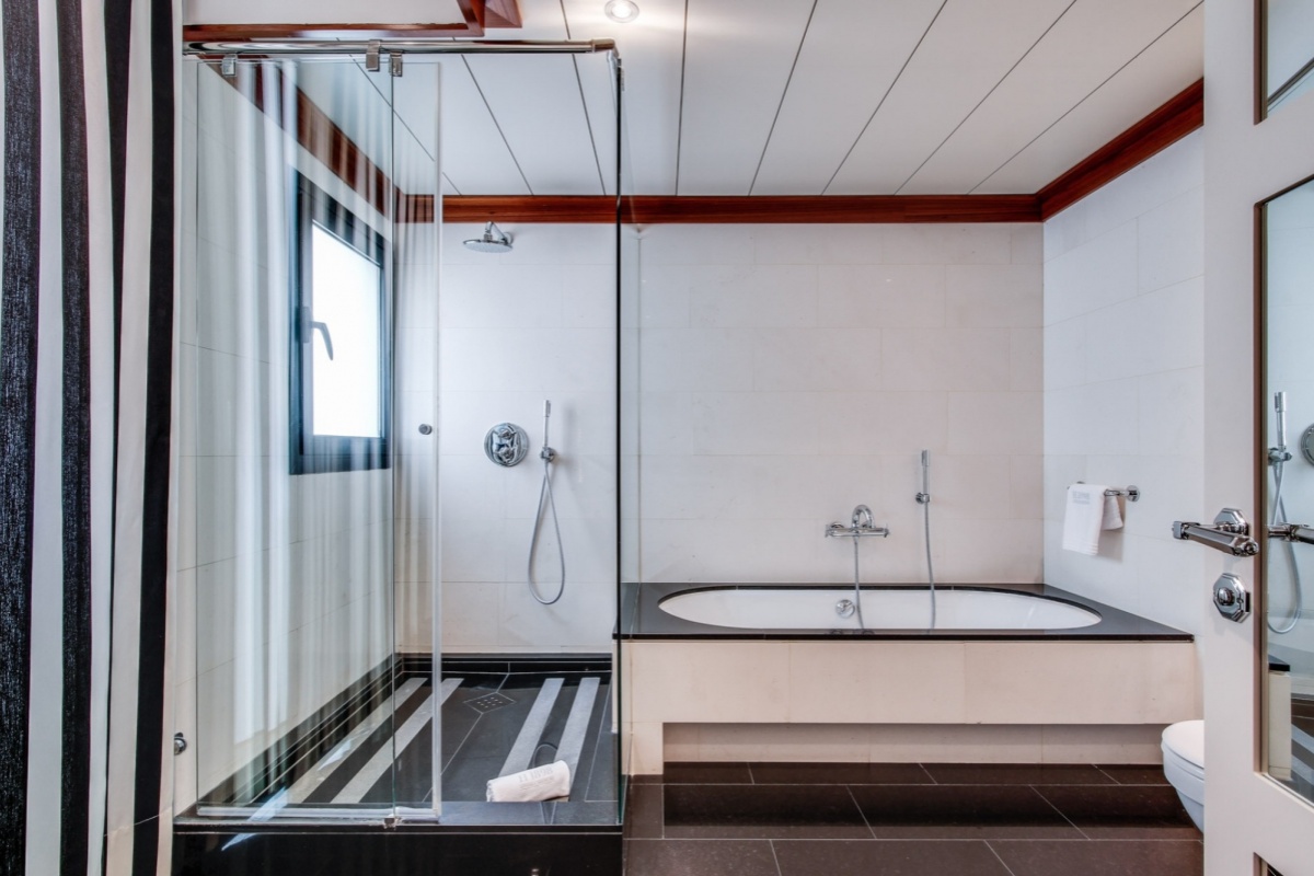 Hotel 1898 - a bathroom with a glass shower and tub