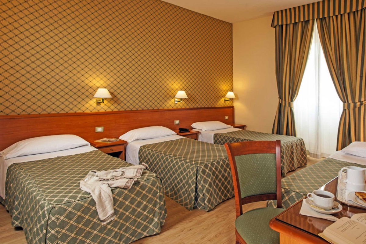 Hotel Colosseum - Triple hotel bedroom with contemporary furnishings and plush bedding.