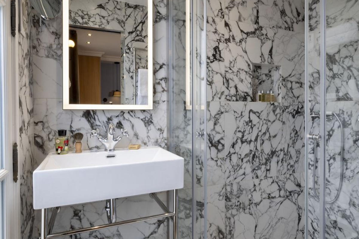 Hotel de Londres Eiffel - a bathroom with a mirror and a sink