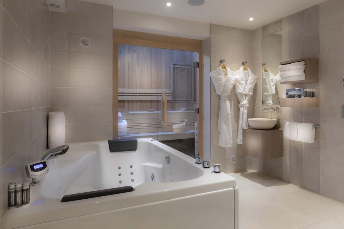 Hotel du Cadran - a bathroom with a bathtub and a sink
