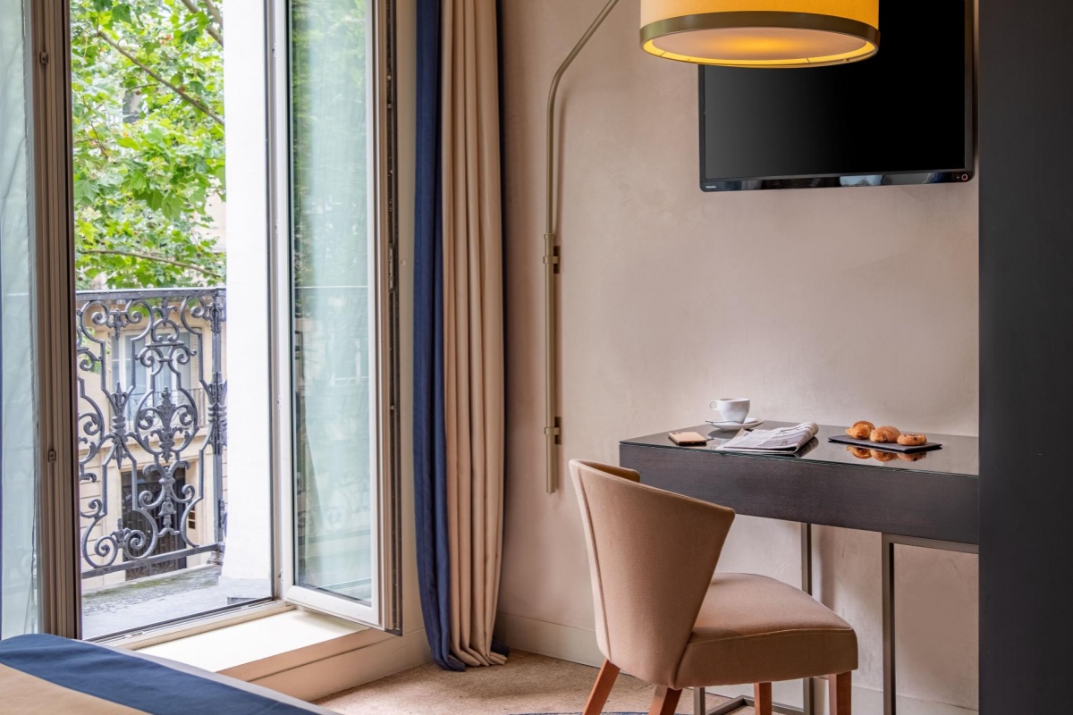 Hotel La Bourdonnais - a room with a desk and a tv
