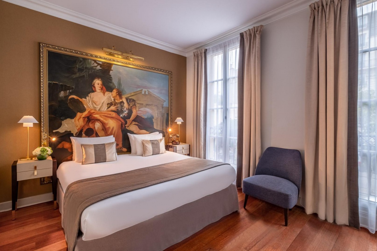 Hotel Le Walt - a bedroom with a large painting on the wall