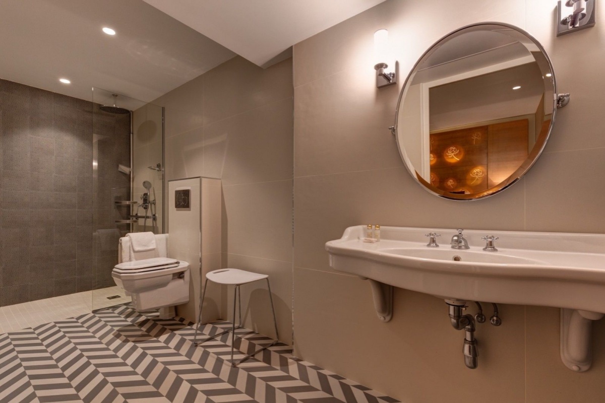 Hotel Muguet - a bathroom with a mirror and a toilet