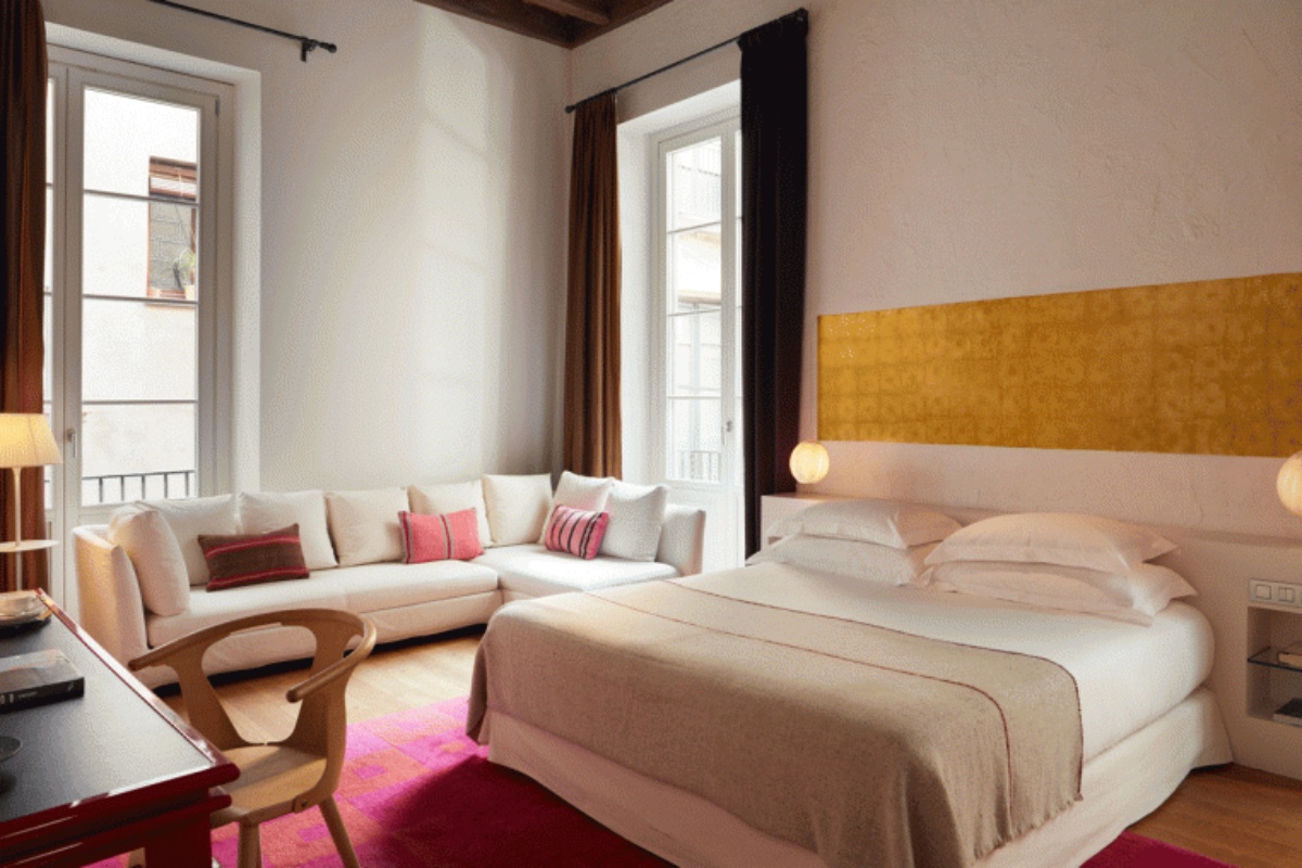 Hotel Neri Relais & Chateaux - a bedroom with a couch and a bed