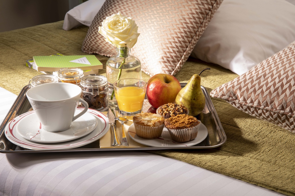 Hotel Relais Bosquet Paris by Malone - a tray of breakfast on a bed