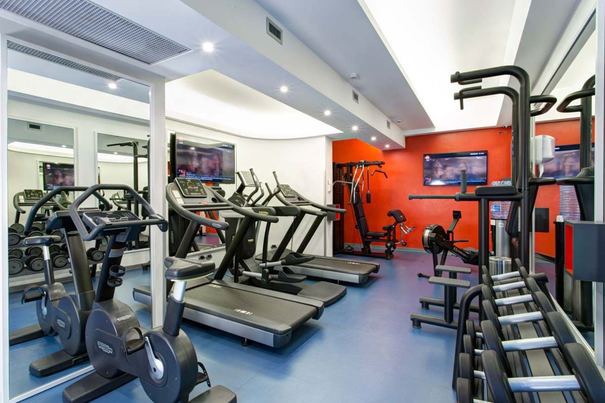 iQ Hotel Roma - Hotel gym with exercise machines.