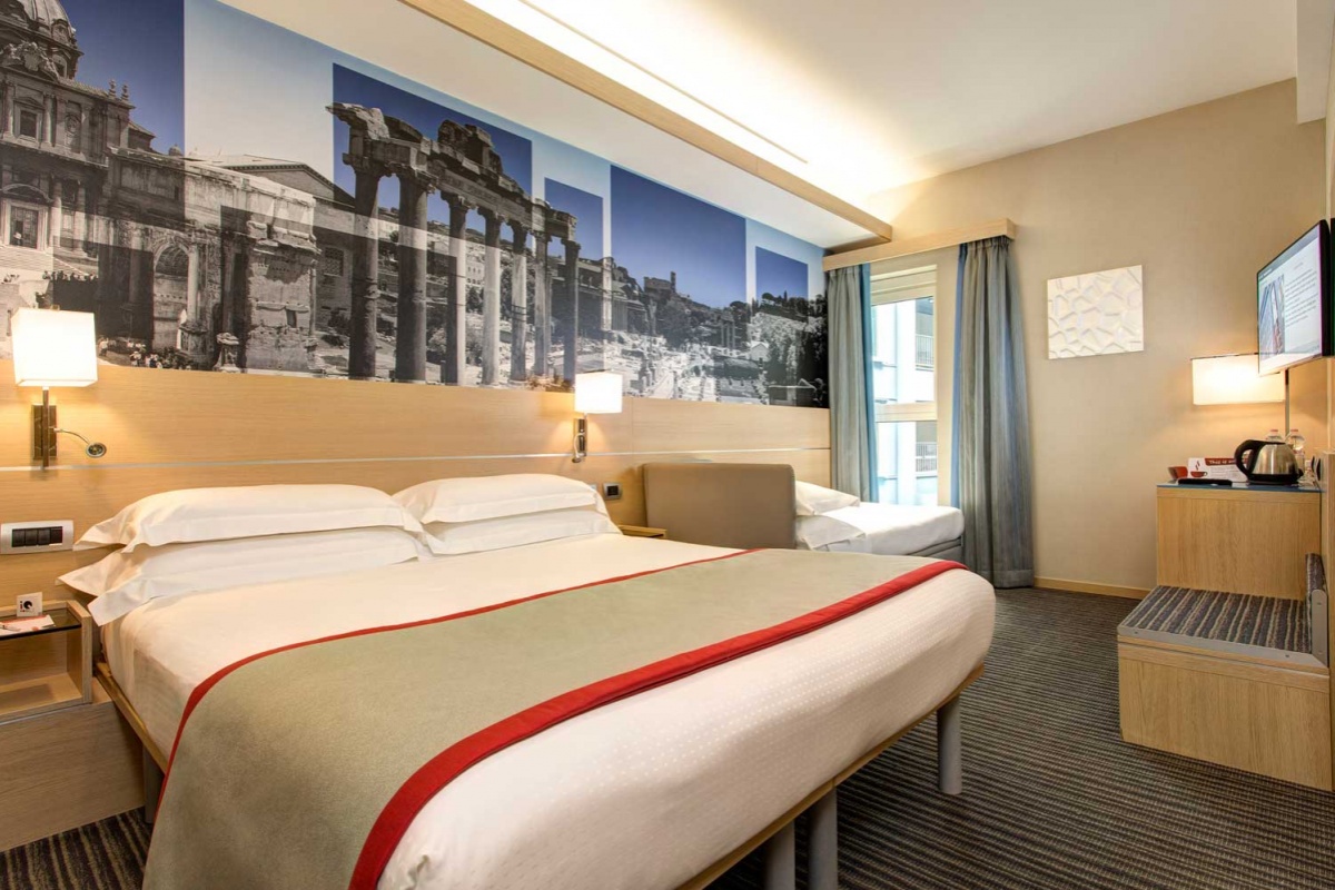 iQ Hotel Roma - Luxury double room with soft lighting and contemporary furnishings.