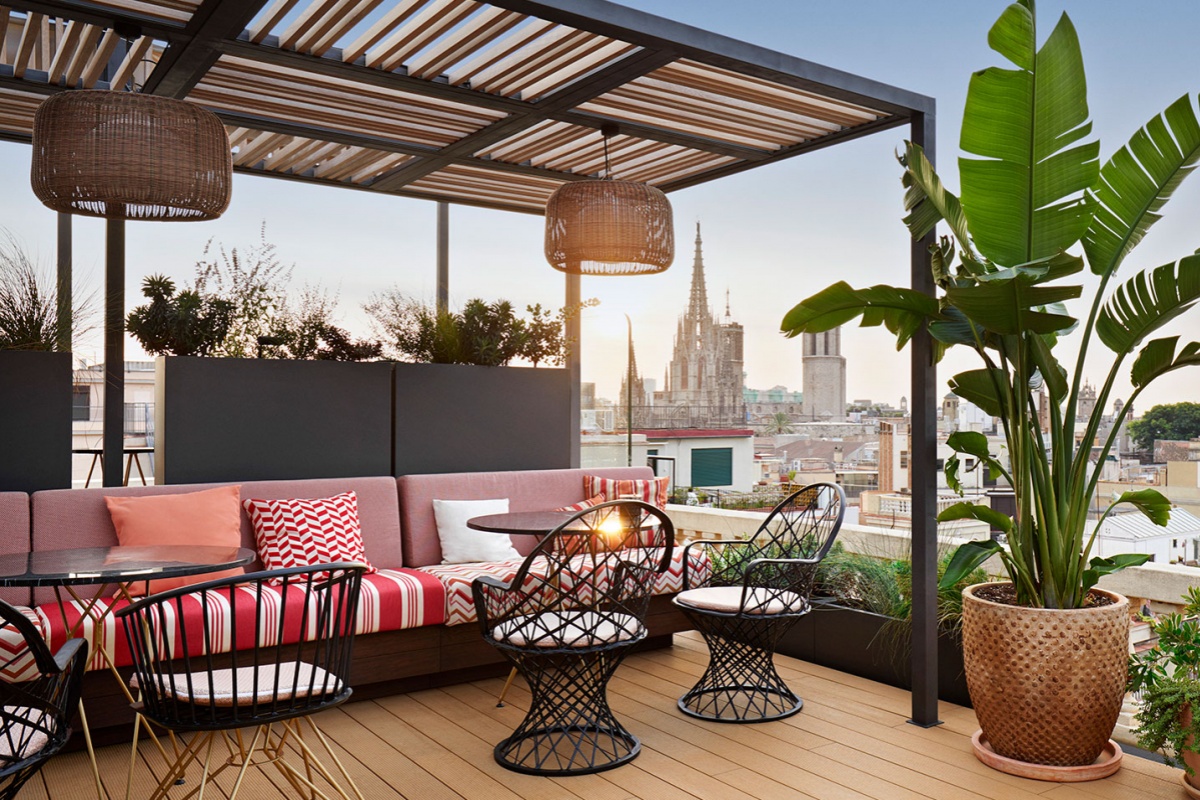 Kimpton Vividora Hotel - a patio with a table and chairs and a large planter