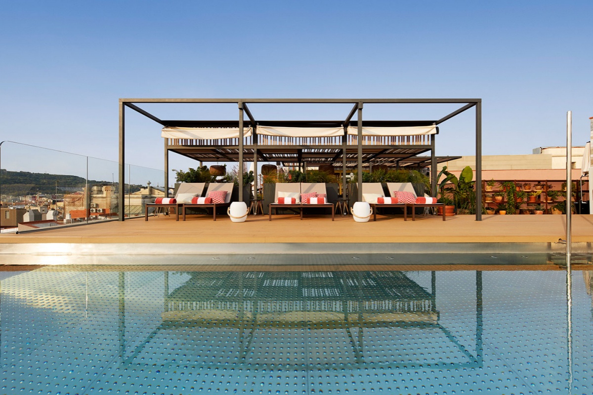 Kimpton Vividora Hotel - a pool with a deck and chairs
