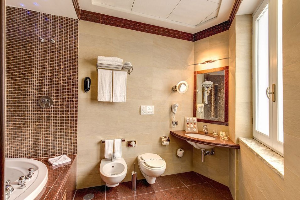 Kolbe Hotel Rome - A bathroom with a sink, toilet, bathtub and bidet. 