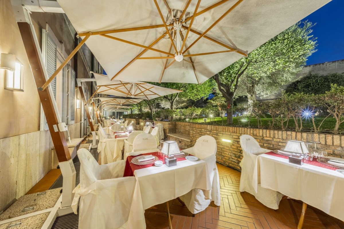 Kolbe Hotel Rome - An outside garden restaurant with olive and citrus trees.