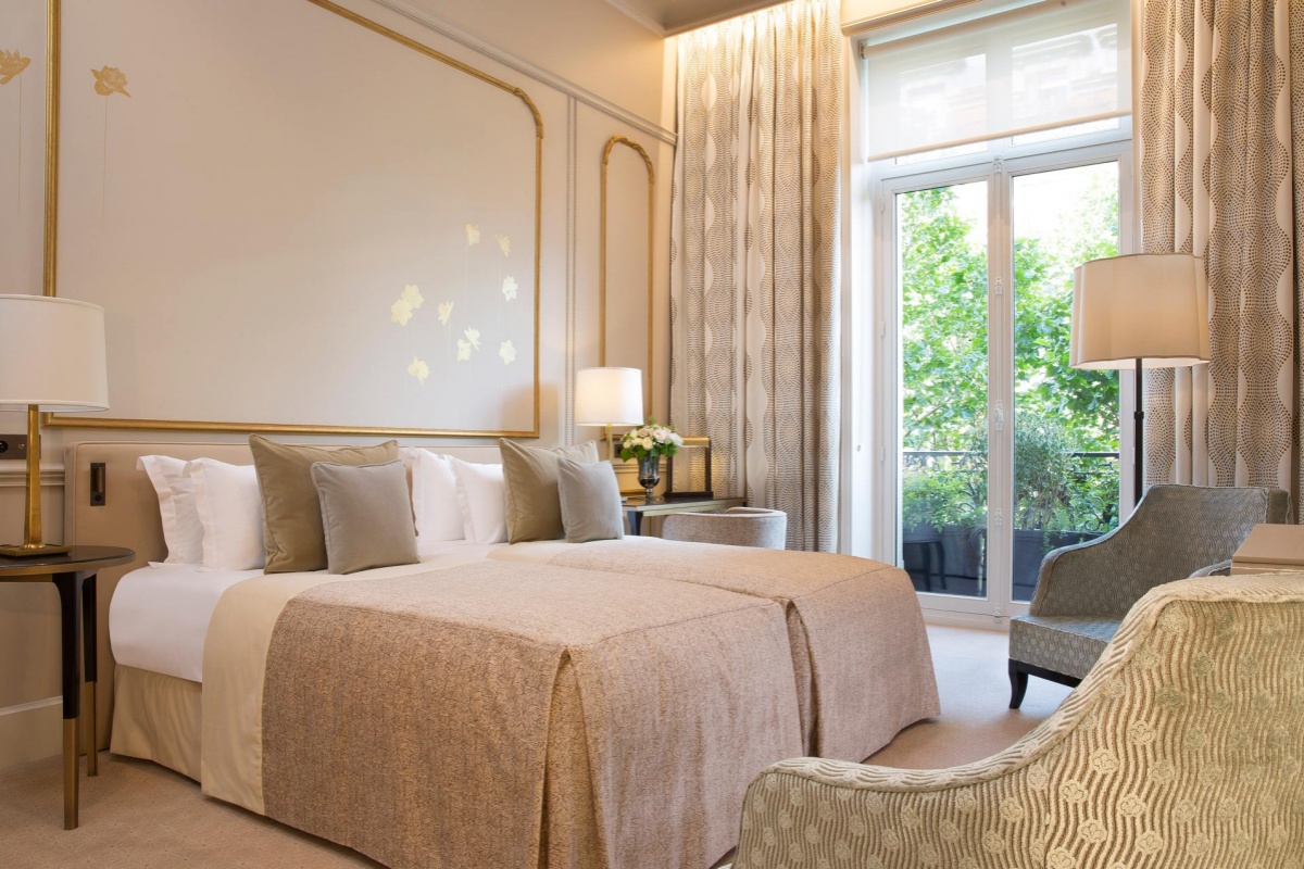 Le Narcisse Blanc Hotel & Spa - a bedroom with a bed and a chair