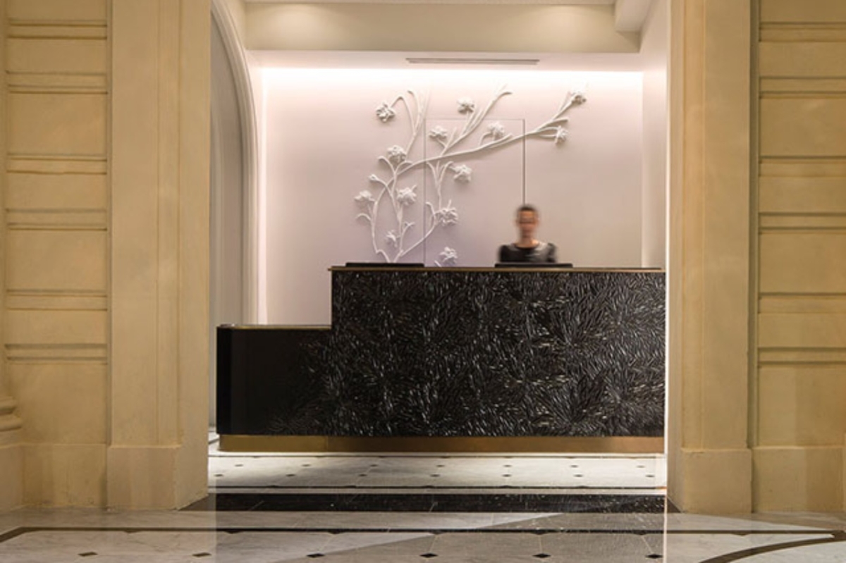 Le Narcisse Blanc Hotel & Spa - a person behind a black reception desk