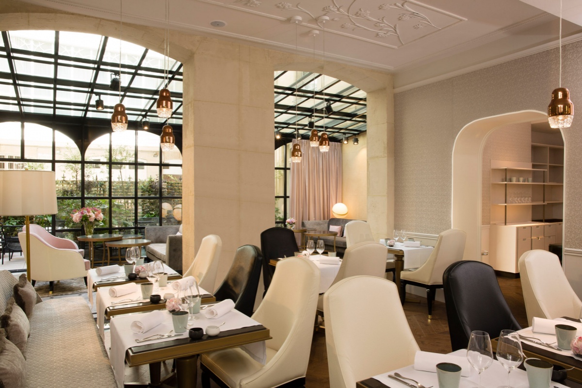 Le Narcisse Blanc Hotel & Spa - a restaurant with tables and chairs