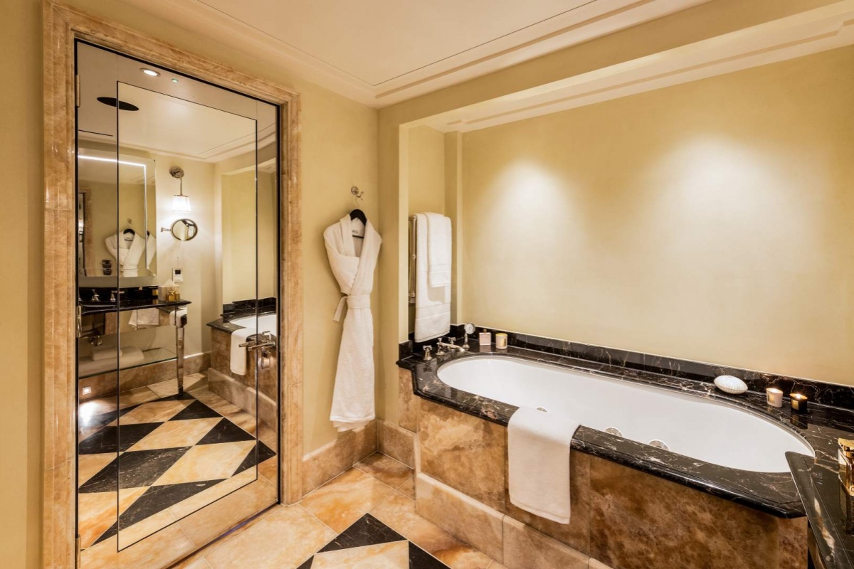 L'oscar London - a bathroom with a bathtub and a mirror