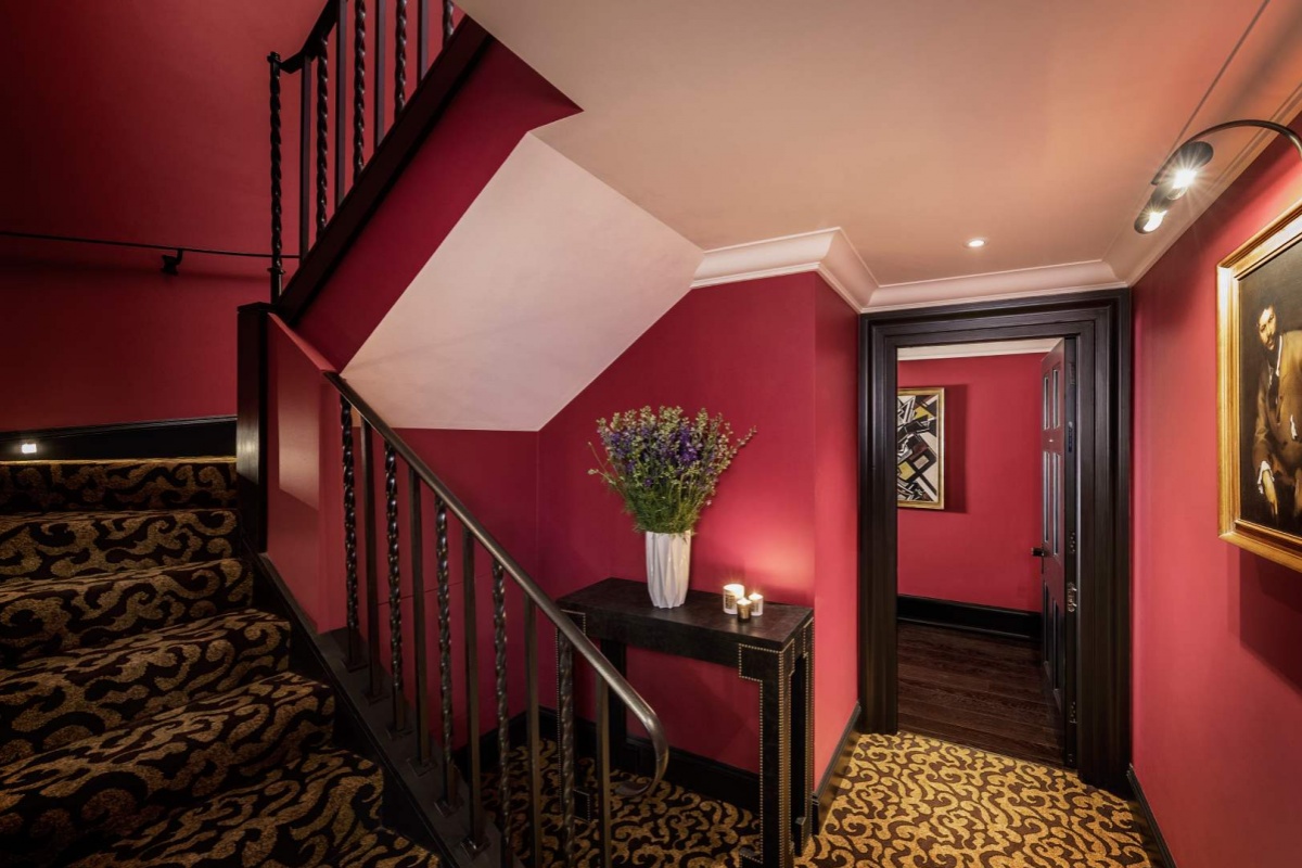 L'oscar London - a hallway with a staircase and a vase of flowers