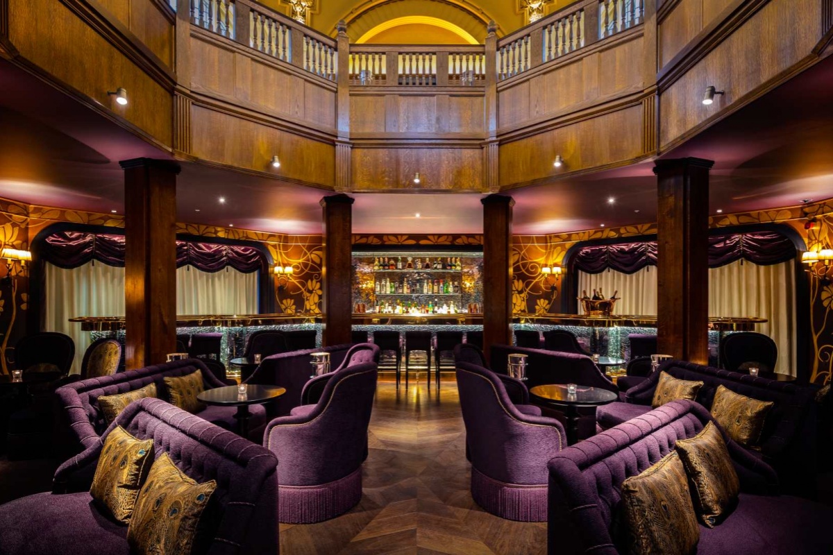 L'oscar London - a room with purple furniture and a bar