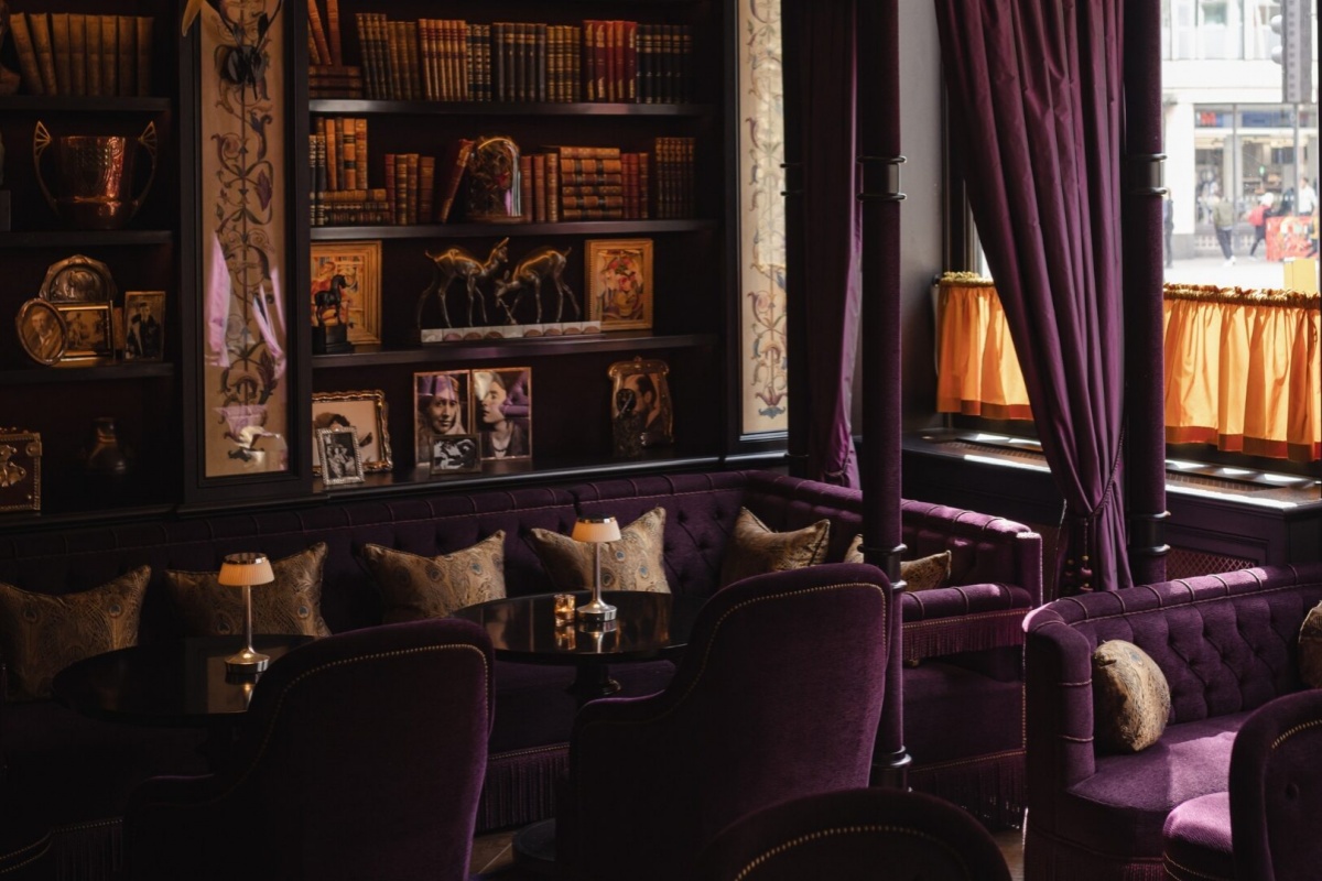 L'oscar London - a room with purple furniture and bookshelves