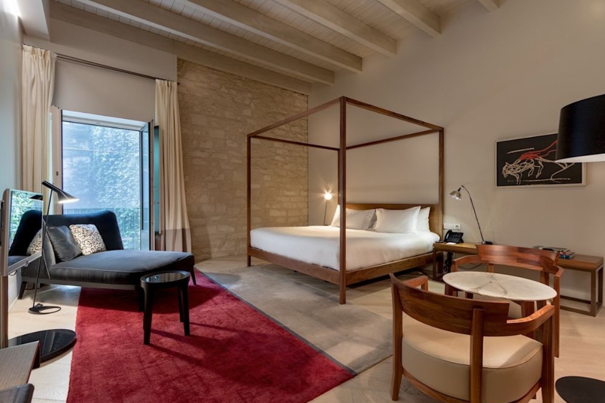 Mercer Hotel Barcelona - a bedroom with a bed and a chair