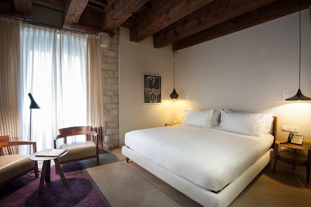 Mercer Hotel Barcelona - a bedroom with a bed and a chair