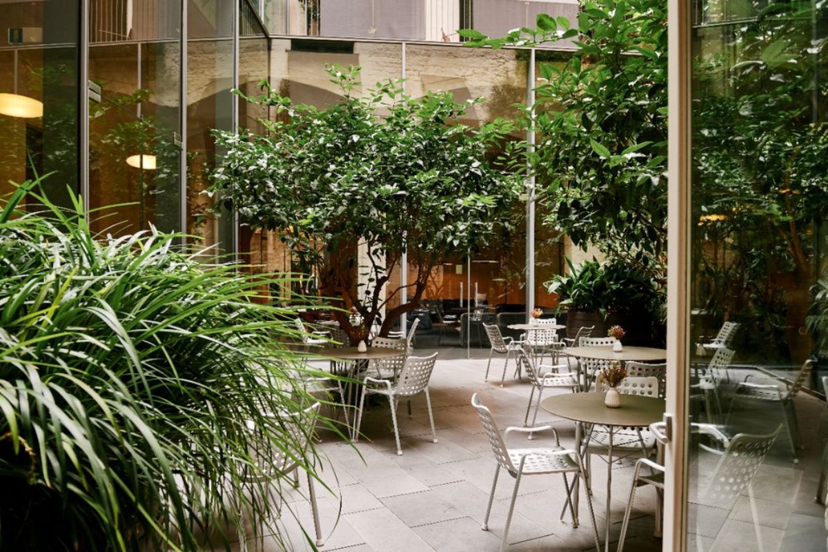 Mercer Hotel Barcelona - a patio with tables and chairs and trees