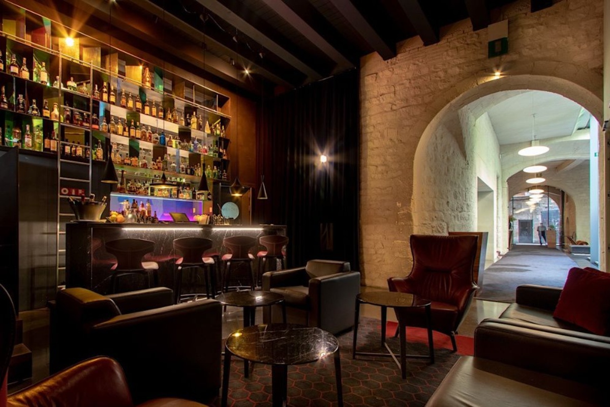 Mercer Hotel Barcelona - a room with a bar and a shelf of liquor bottles