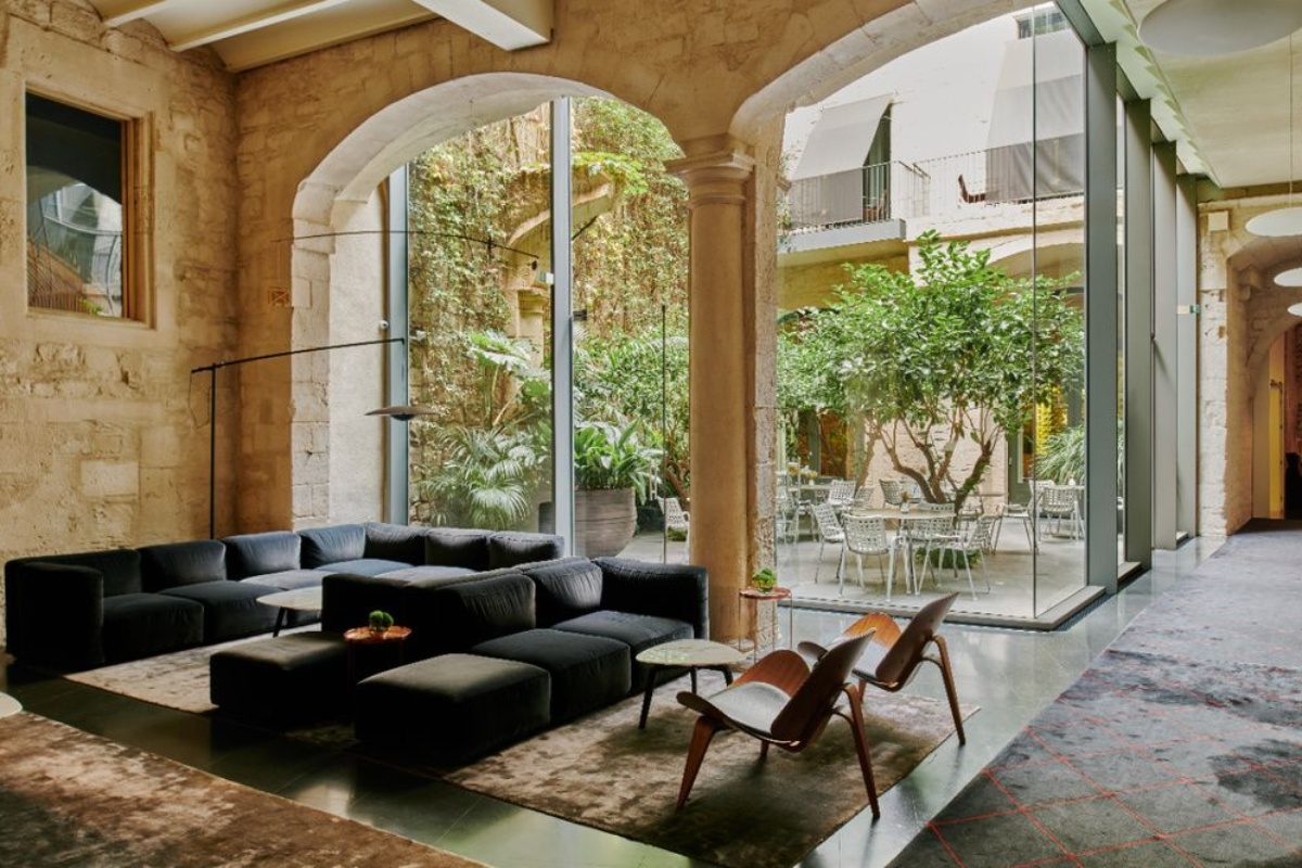 Mercer Hotel Barcelona - a room with a large glass wall and a large couch