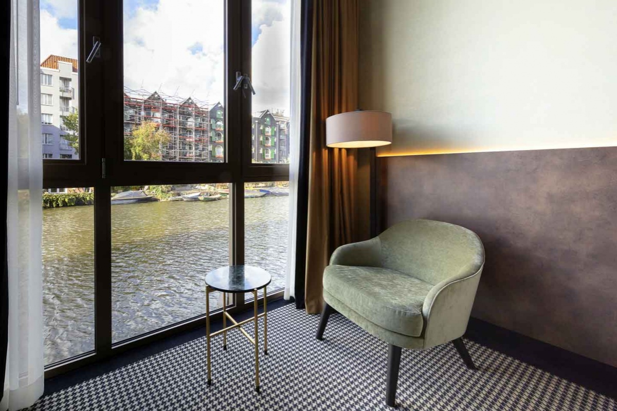 Monet Garden Hotel Amsterdam - a chair next to a window