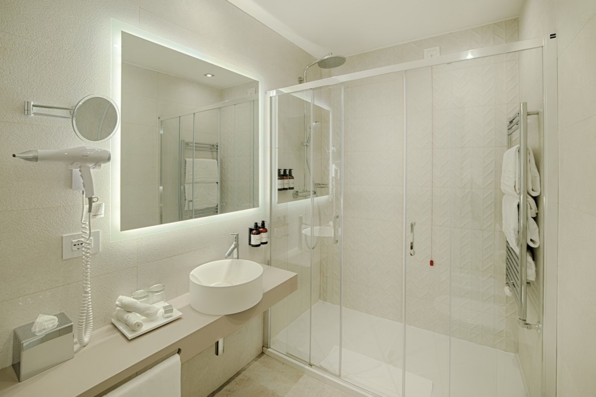 NH Collection Roma Fori Imperiali - Modern bathroom with a shower and tub combination.