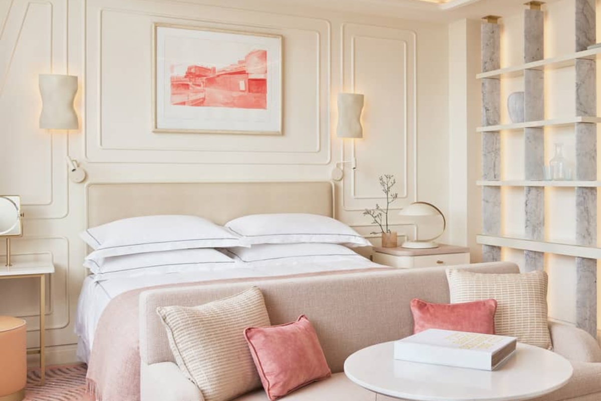 One Aldwych - a bed with pillows and a table in a room