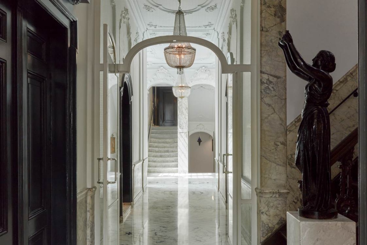 Pulitzer Amsterdam - a marble hallway with a statue of a woman