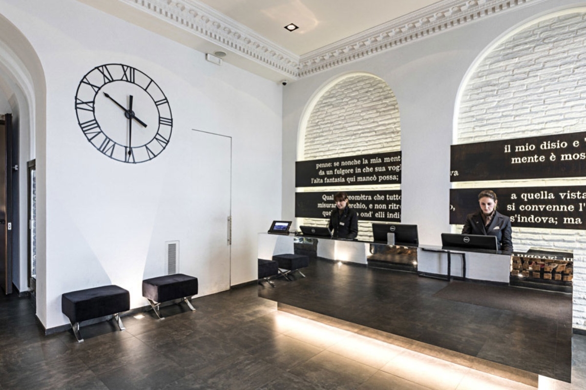 Rome Times Hotel - Hotel reception area with large wall clock and contemporary black and white decor.